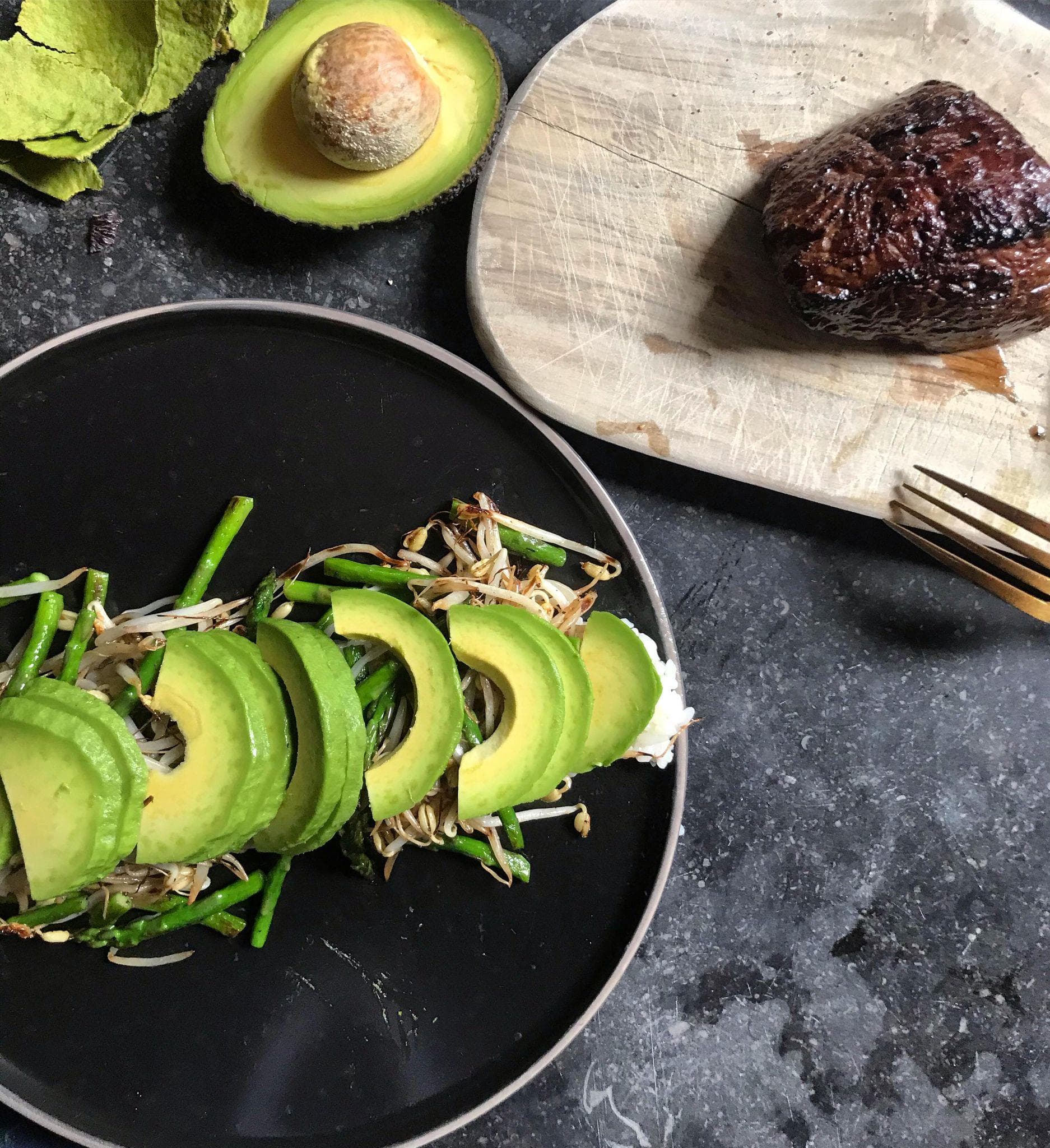 De gebakken ossenhaas afgeblust met soja saus op een bedje ban avocado, sushi, tauge en groene asperges.